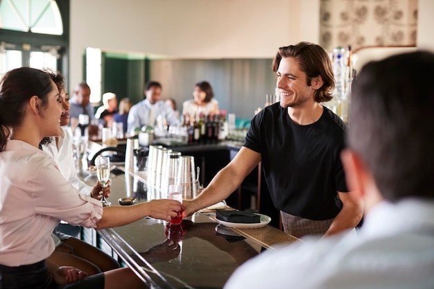 bartender serving two businesswomen meeting after works drinks 625516 1883